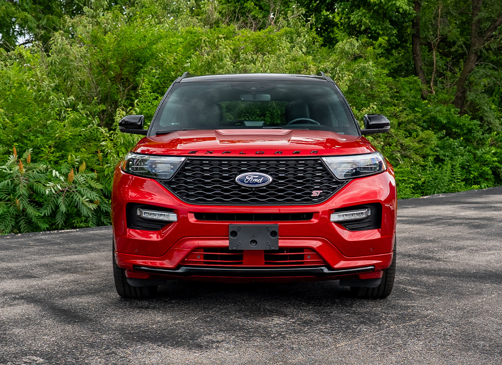 Front end of a 2022 Rapid Red Ford Explorer with color matched front bumper cladding.